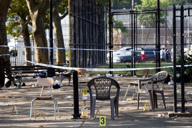Yellow evidence markers are placed next to chairs at a playground in the Brownsville neighborhood in the Brooklyn borough of New York after Saturday night's shooting